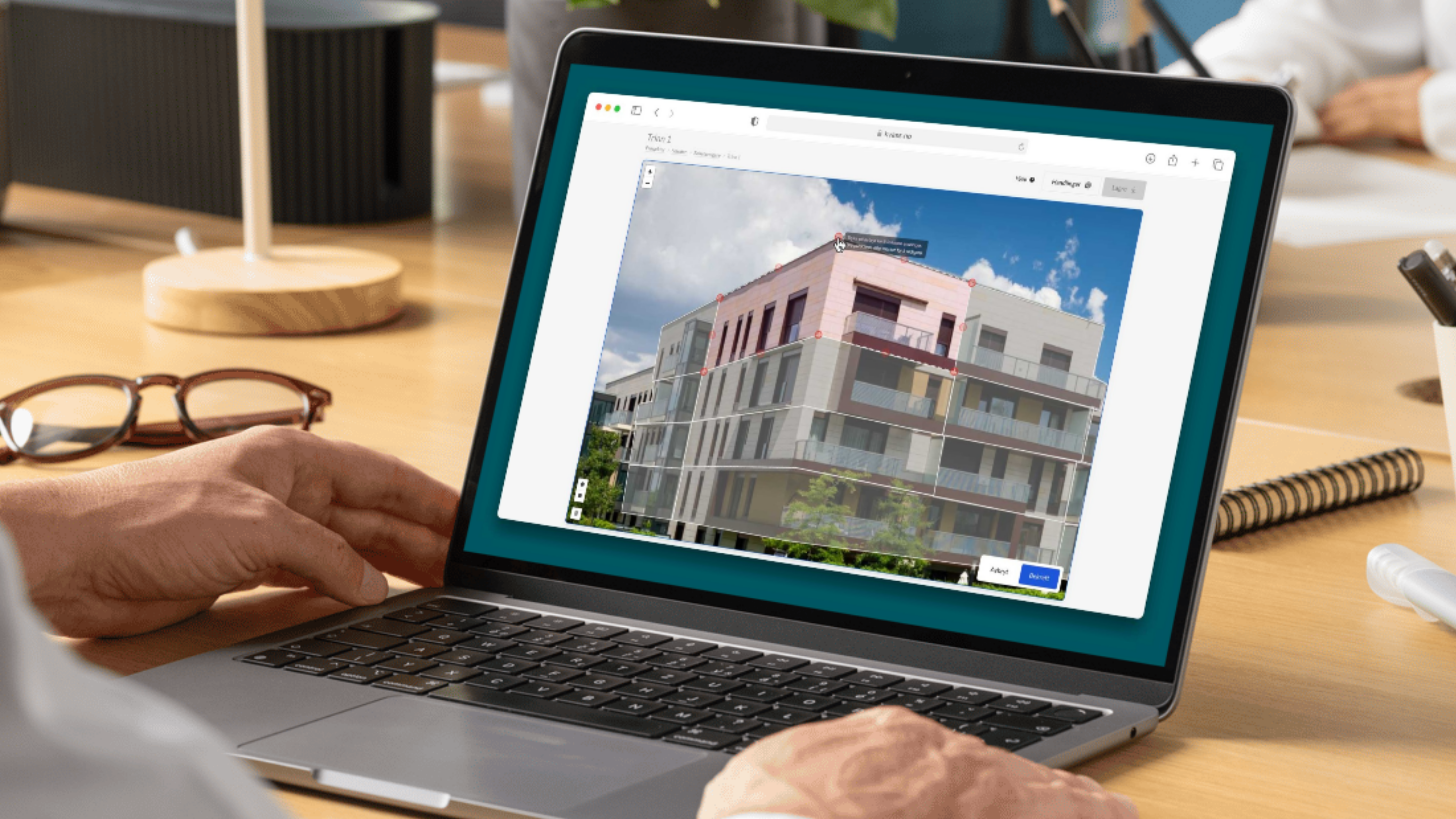 Person redigerar bostadsväljare på laptop med markerade enheter på en flerbostadsbyggnad.